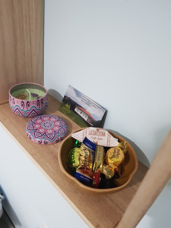 Des détails de bienvenue préparés avec amour, une bougie fabriquée par moi, des bonbons et un aimant maison.