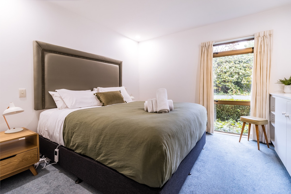 This sunny bedroom overlooks the garden and features a plush king-size bed with a lush bedhead, gorgeous Kiwi artwork, and wireless charging at your fingertips. It's the kind of room where you’ll sleep in and still want to lounge around all day.