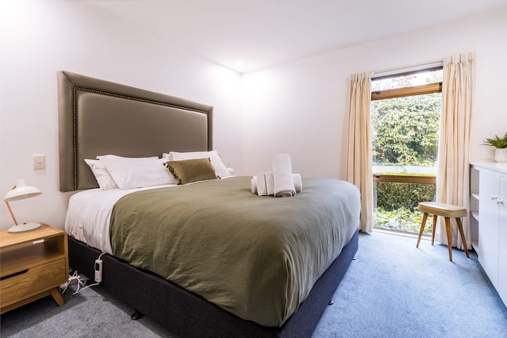 This sunny bedroom overlooks the garden and features a plush king-size bed with a lush bedhead, gorgeous Kiwi artwork, and wireless charging at your fingertips. It's the kind of room where you’ll sleep in and still want to lounge around all day.