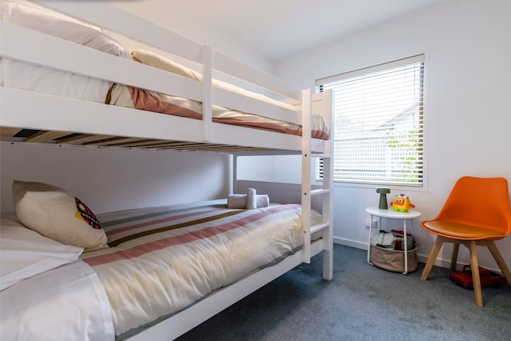 The second kids’ room has a comfy king single bunk bed, soft lighting with a touch lamp, and toys to keep the little ones entertained. Whether it’s a sleepover, quiet play, or story time, this space is made for mini guests with big imaginations.
