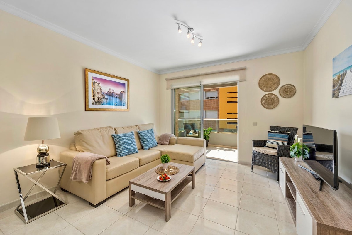 Bekvämt vardagsrum, utrustat med en bäddsoffa (140x200), TV, IPTV-åtkomst och höghastighets Wi-Fi. Det har en dörr som ger direkt tillgång till den privata utomhusbalkongen, med en trevlig utsikt över lägenheten poolen.