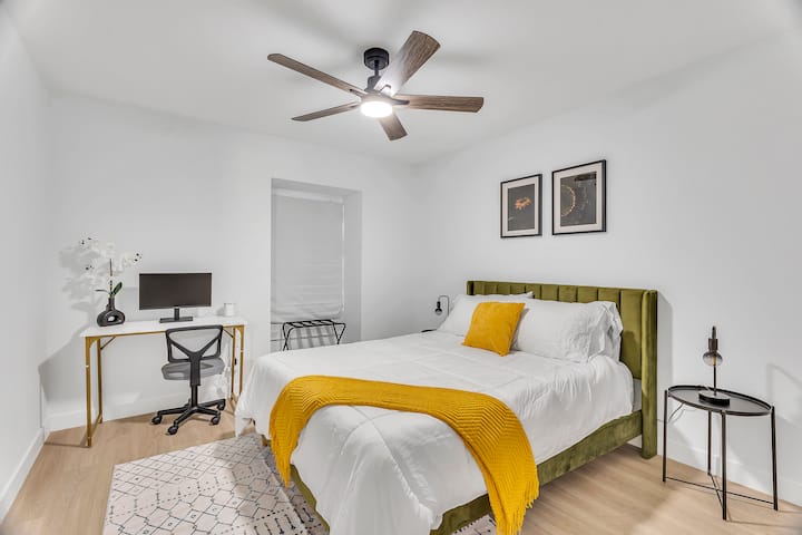 Útočisko na produktivitu s manželskou posteľou Queen a písacím stolom, ktoré zahŕňa monitor - ideálny pre pracovníkov na diaľku.