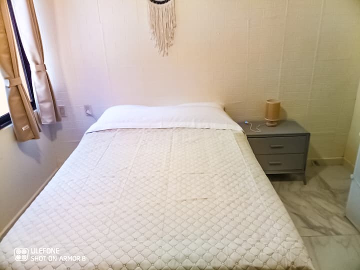 ACOGEDORA RECAMARA QUE CUENTA CON CAMA INDIVIDUAL, BURO Y LAMPARA DE NOCHE