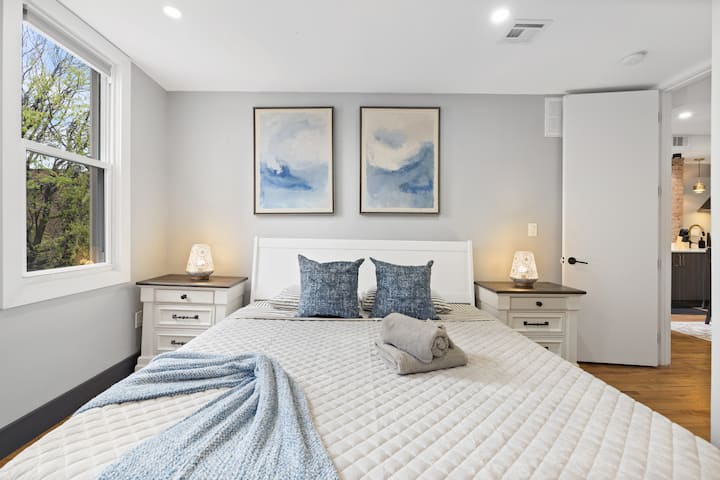 חדר שינה ראשי מרווח עם מיטת קינג סייז ומצעים רכים ללילה של מנוחה.