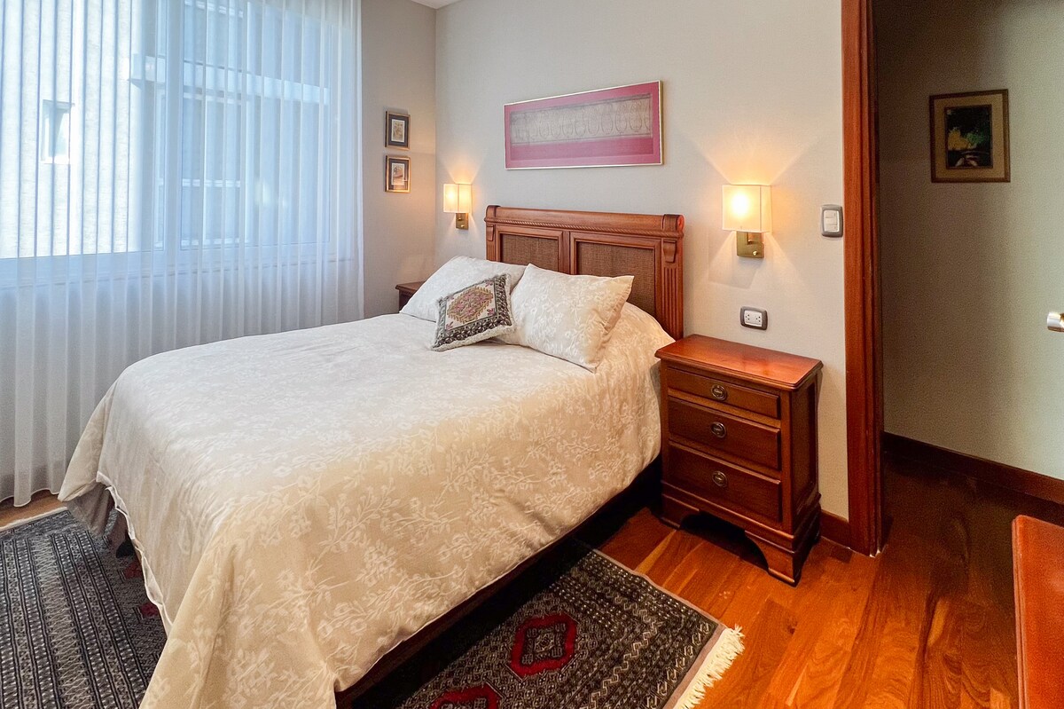 一张标准双人床、埃及豪华棉床单和宽大的枕头，邀请您入睡。 温暖的灯光营造出温馨轻松的氛围，非常适合阅读或分享特殊时刻。  