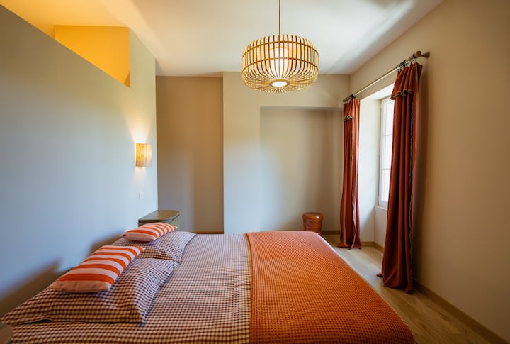 ห้องสวีทใหญ่พร้อมเตียงควีนไซส์ โต๊ะทำงาน และห้องอาบน้ำที่มีฝักบัวอาบน้ำของตัวเอง