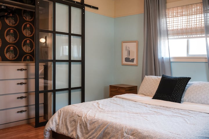 Dormitorio relajante con cama tamaño Queen, sofá cama y amplio espacio de almacenamiento.