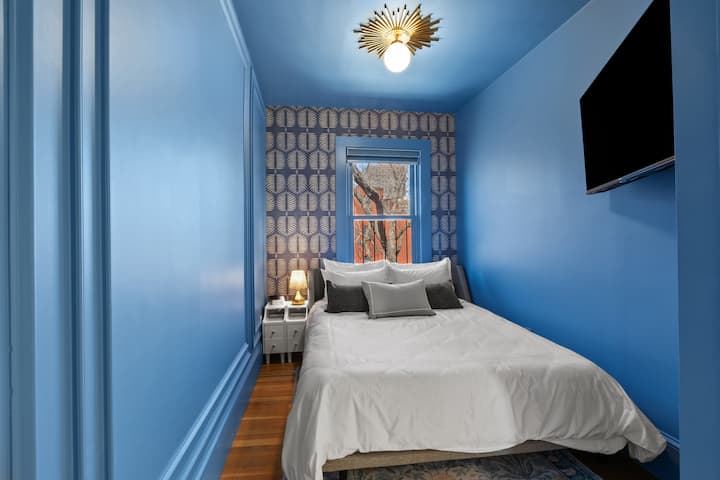 Táto odvážna a útulná spálňa pre hostí má bohaté modré steny, hravý vzorovaný prízvuk a teplé prirodzené svetlo, ktoré ponúka štýlové, zastrčené útočisko so správnym množstvom drámy.