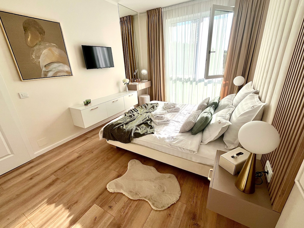 მკაფიო, ჰარმონიული საძინებელი კარგად შერჩეული ნამუშევრებით, ტუალეტის კუთხითა და სმარტ‑ტელევიზორით.
დიდი ფანჯრებიდან ბუნებრივი სინათლე შემოდის, რბილი ტექსტურები და კარგად მოფიქრებული დეტალები კი მშვიდ, დასასვენებელ გარემოს ქმნის.