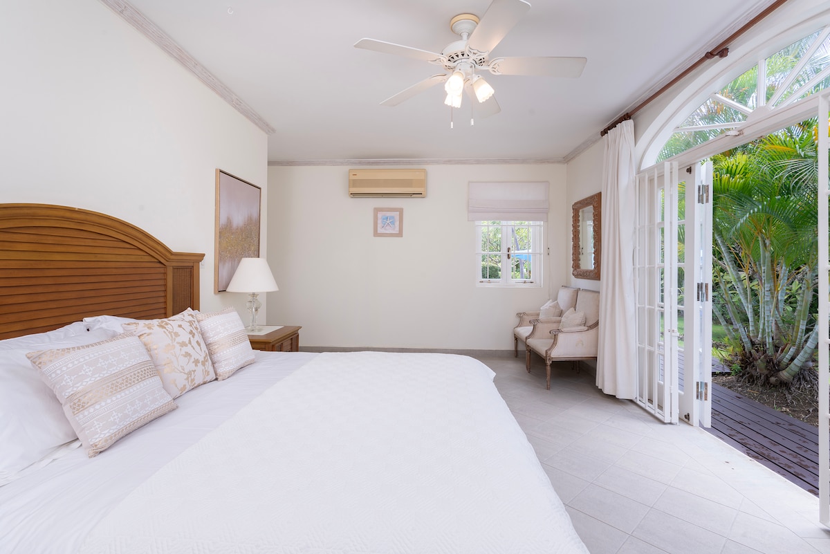 Tranquil bedroom 2 with a UK king size bed, TV, french doors to the garden and en suite.  