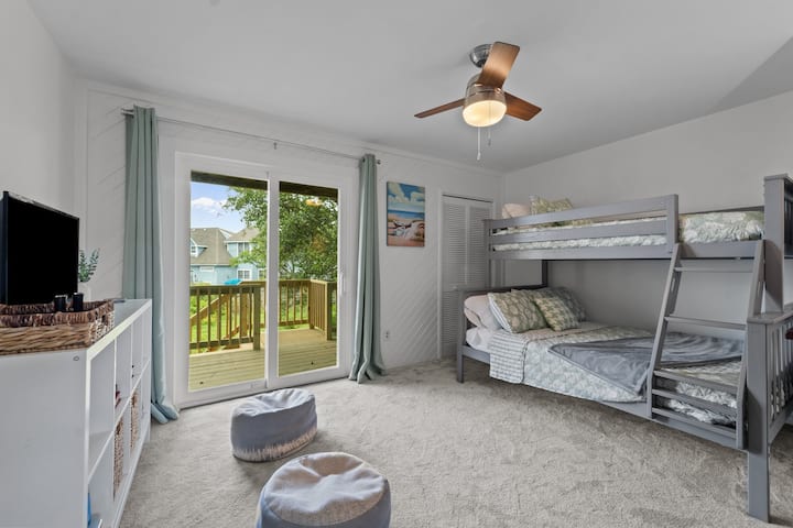 Cette chambre au deuxième étage dispose d'un lit simple superposé sur un lit double et d'un coin de jeu amusant. Toutes les chambres ont accès à des terrasses extérieures.