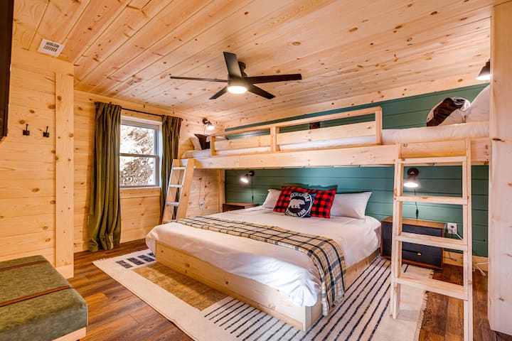 Postavené pre zábavu a pohodlie — vlastné poschodové postele s dvoma oddelenými posteľami XL nad manželskou posteľou robia z tejto izby ideálnu izbu pre deti alebo rodiny.