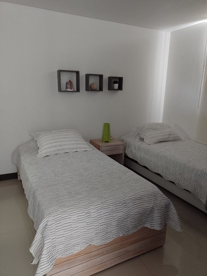 habitacion con dos camas sencillas y una pequeña cama debajo