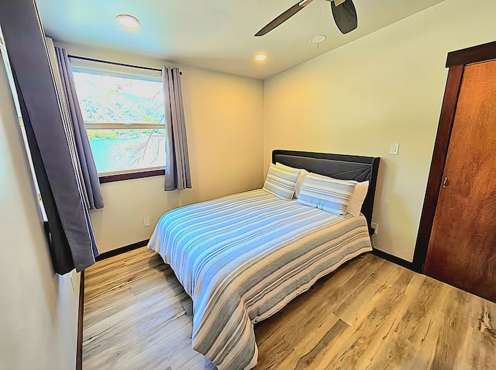 Bedroom 2 features a comfy queen bed for adults and a twin-over-twin bunk bed for children. Enjoy plenty of natural light and a beautiful lake view in this bright, family-friendly space.