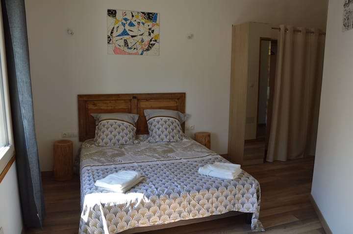 Пространа спална соба со соблекувална и биро.