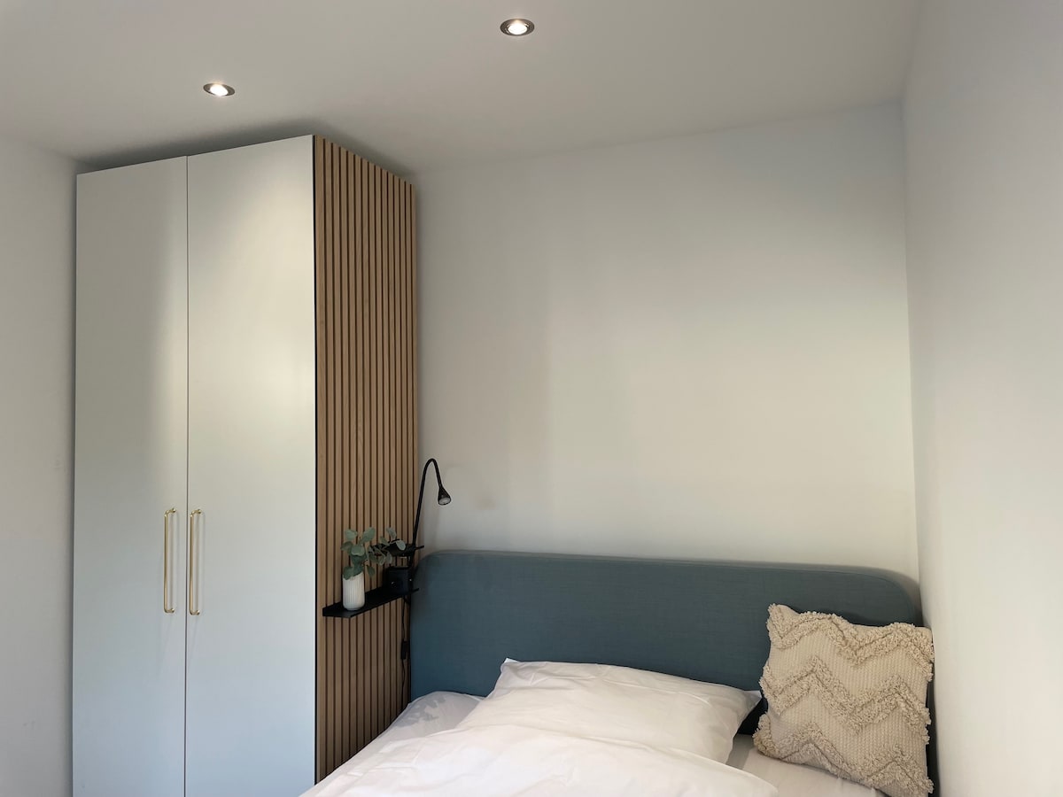 Schlafzimmer mit einem Queen-Size-Bett (140 cm x 200 cm) und einem Single-Bett (90 cm x 200 cm).