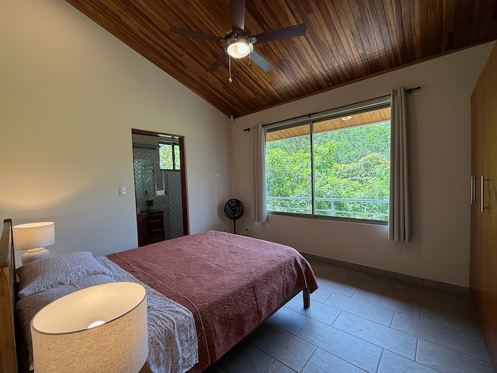 Queen bed with side table and lamps. Ceiling fan. 