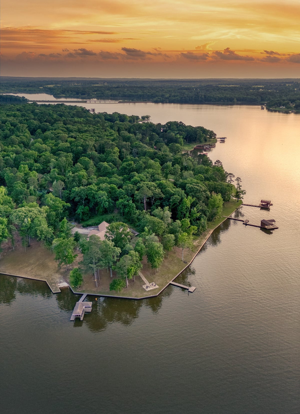 Aerial view of Lake Bob Sandlin shoreline and fishing piers at sunset near Eagle's Nest Lakehouse