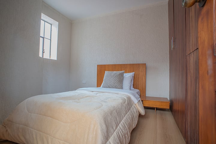 Единечен кревет, плакар од подот до таванот и топол декор. Идеално за гостин кој бара приватност и удобност.