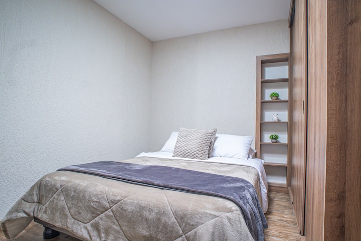 Дупли кревет со трезна декорација и функционална полица. Интимен простор за длабок одмор.