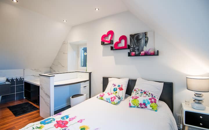 A l'étage : chambre lumineuse avec lit 140 cm, coin bureau et placard. Salle de bain privative intégrée. Climatisée, avec deux fenêtres ouvertes sur la nature. Un cocon confortable pour se détendre.