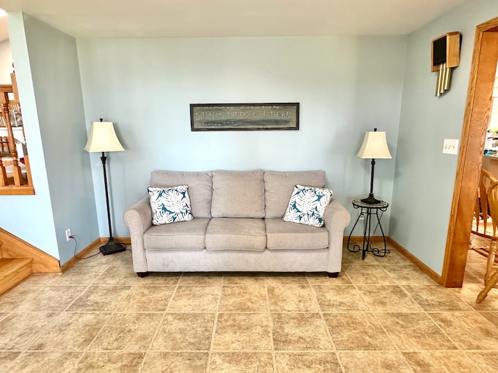 Зона за сядане с изглед към езерото с удобни дивани, подредени за разговор.