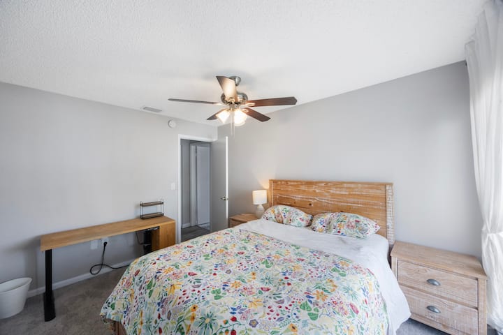 Spavaća soba s bračnim krevetom i stolom za rad u sjedećem i stojećem položaju za goste koji rade na daljinu