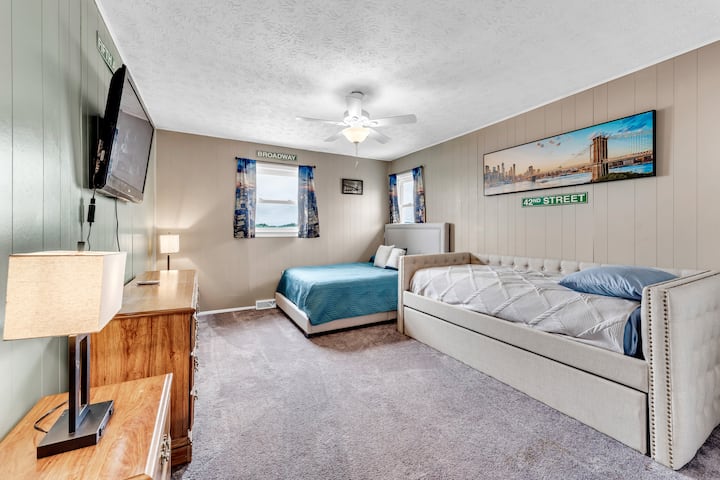 New York themed bedroom with twin day bed, twin trundle, and full size bed. Also has 40" TV.