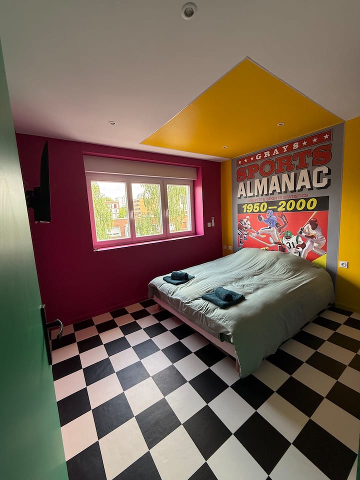 Chumba cha kukaribisha chenye kitanda cha watu wawili na mapambo ya ukutani ya kimaridadi, kwa ajili ya mapumziko ya amani katika mazingira ya starehe