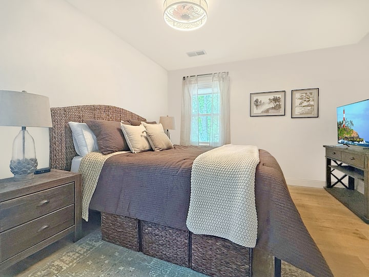 Опуштете се во стилска, осветлена од сонцето брачна спална соба со удобна кафеава постелнина, луксузно фрлање крем, 43-инчен телевизор со рамен екран и елегантен декор. Вашето совршено место за одмор ве чека!