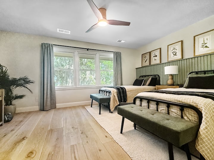 Опуштете се во стилска спална соба со два удобни единечни кревета, шик зелени клупи, сончеви дрвени подови, 42 инчен телевизор и прекрасна ботаничка уметност. Големите прозорци и смирувачкиот декор го прават совршеното место за одмор.