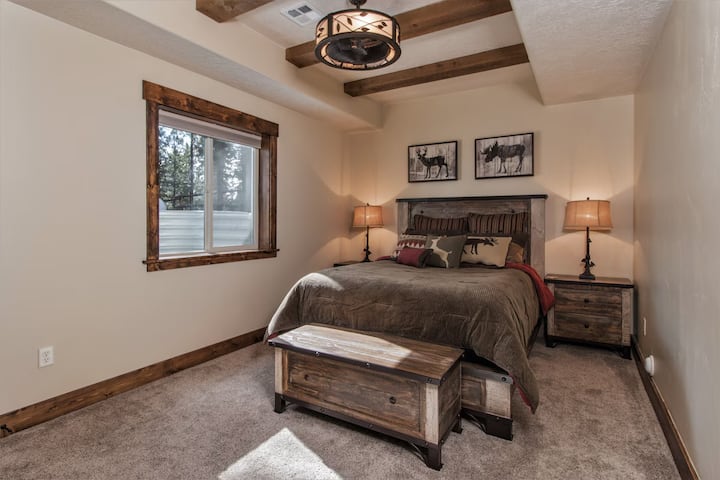 Retiro rústico con una cama tamaño queen, una decoración acogedora de estilo lodge y una iluminación suave. Un espacio cómodo para relajarse después de un día de exploración.