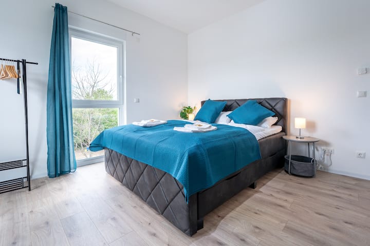 Acogedora habitación con cama con somier, sofá cama, perchero y un práctico escritorio: aquí encontrarás todo lo que necesitas para disfrutar de días de relax y noches de descanso.