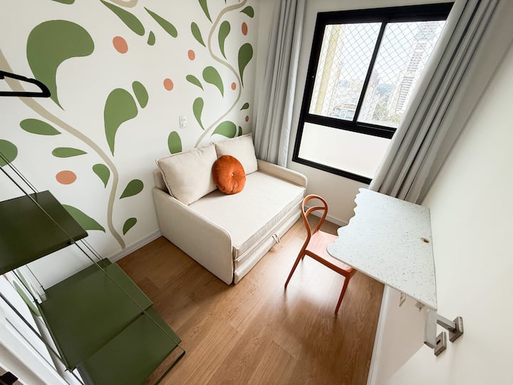 Makuuhuone, jossa on vuodesohva ja sisäänvedettävä pöytä.