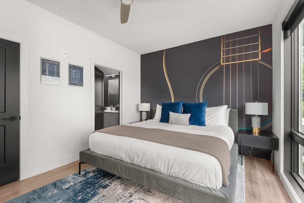 Ამ „გიტარის“ საძინებელში არის დიდი ზომის საწოლი, ოთახის გამუქების ფერები, სმარტ-ტელევიზორი, კომოდი, სრული ზომის სააბაზანო და შესასვლელი კარადა.