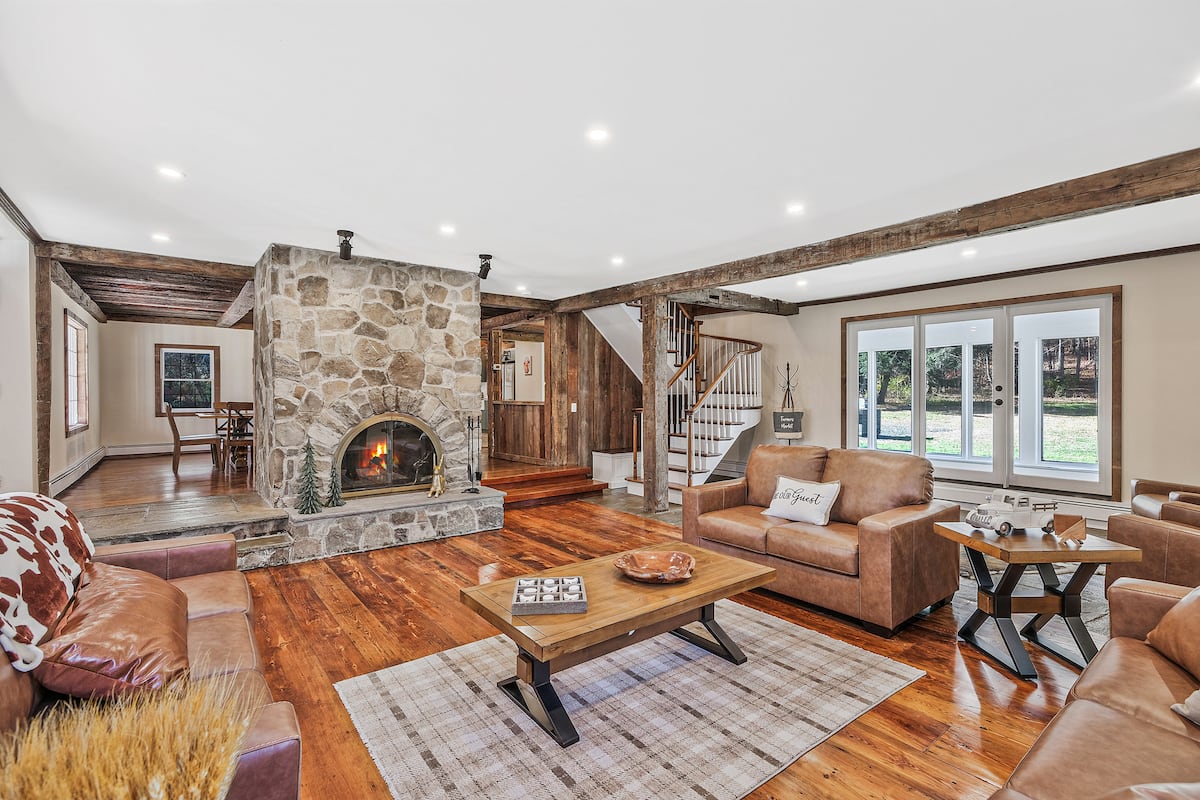 Interior living areas with original stone walls and wood-beam ceilings at Hudson Valley Estate