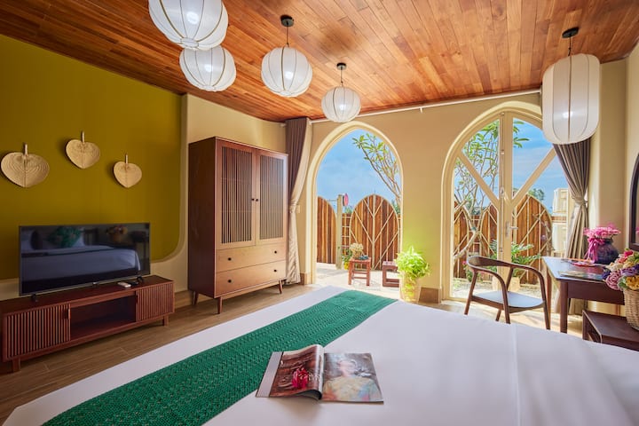 החלונות המקומרים והגדר הירוקה הופכים את חדר השינה הזה למיוחד כל כך