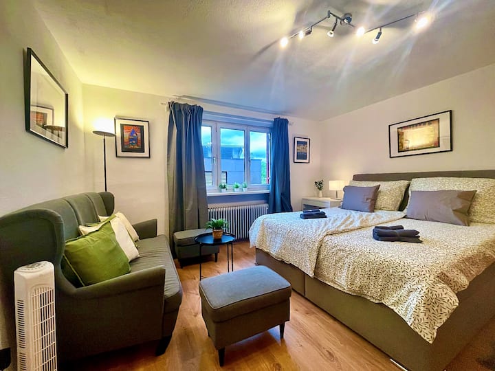 Spálňa s 180 cm manželskou posteľou, ventilátorom a gaučom.