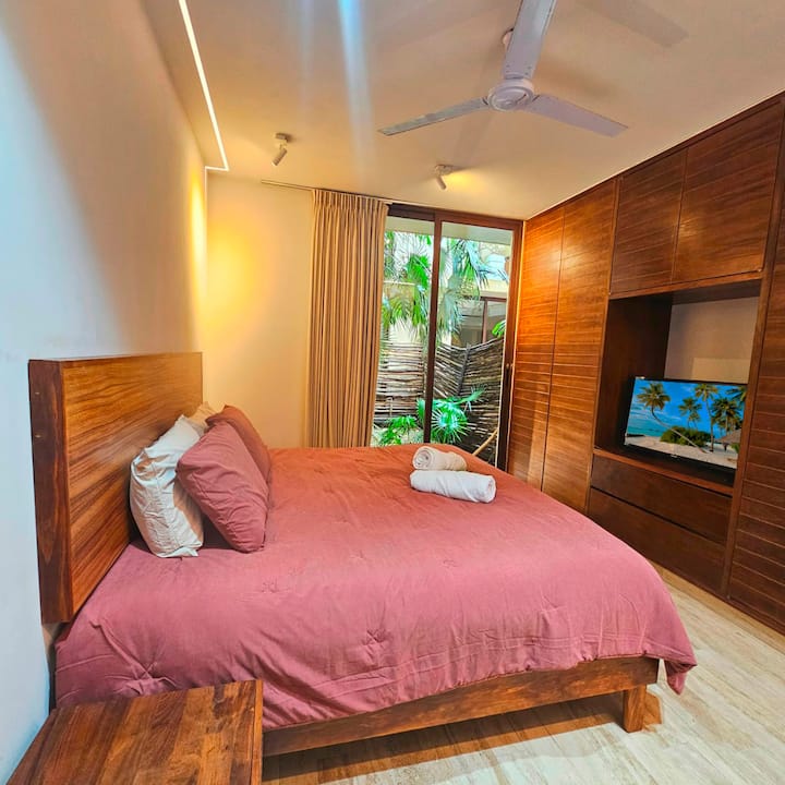 Bedroom for 2 or 3 guests with air conditioning, TV and beautiful views of a tropical garden. Ideal for relaxing and enjoying the nature of Tulum in a comfortable and quiet environment.