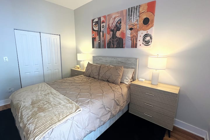 Segundo quarto ensolarado com cama queen size super confortável, ventilador de teto remoto, tapete de pelúcia, mesas de cabeceira duplas de três gavetas, estações de tomada/carregamento e armário grande