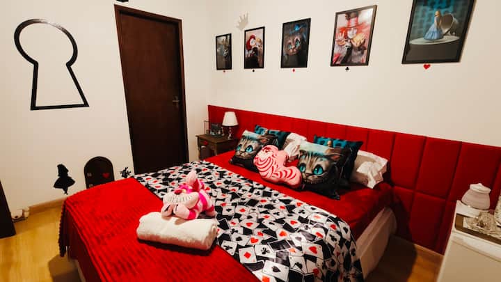 Quarto temático da Alice no País das Maravilhas, com cama queen, frigobar, máquina de café expresso, chaleira, portinha decorativa e diversas decorações