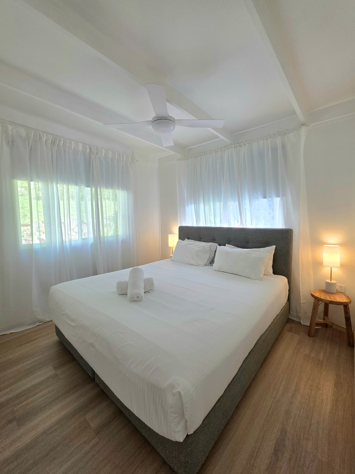 Zelená spálňa na prízemí. 2 veľké okná vpúšťajú svetlo a záhradu 