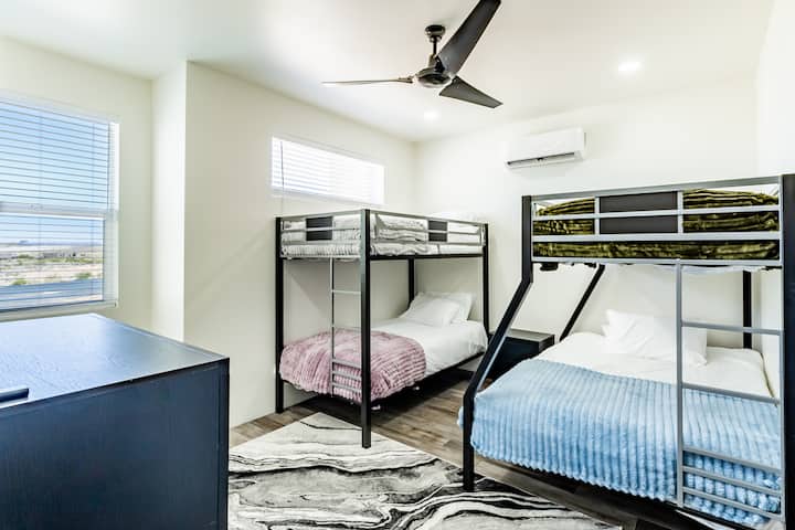 غرفة نوم بطابقين ممتعة ومريحة للأطفال، تحتوي على سرير مزدوج وسرير مزدوج، وتلفزيون 55 بوصة، وكرسي كبير مريح للاسترخاء.