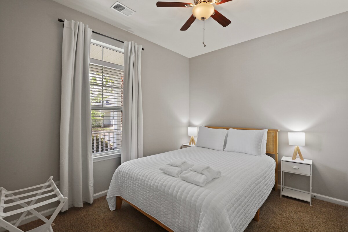 Relájate en este dormitorio sereno con una cómoda cama tamaño queen con persianas que oscurecen la habitación para una noche de sueño reparador. 