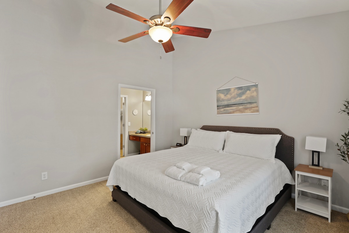 Relájate en el espacioso dormitorio tamaño king con una lujosa cama, una decoración costera relajante y un baño privado. 