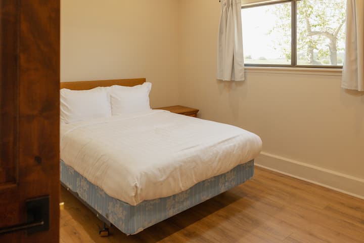 Cozy queen-size bed in the front bedroom with hotel-quality linens and extra blankets.