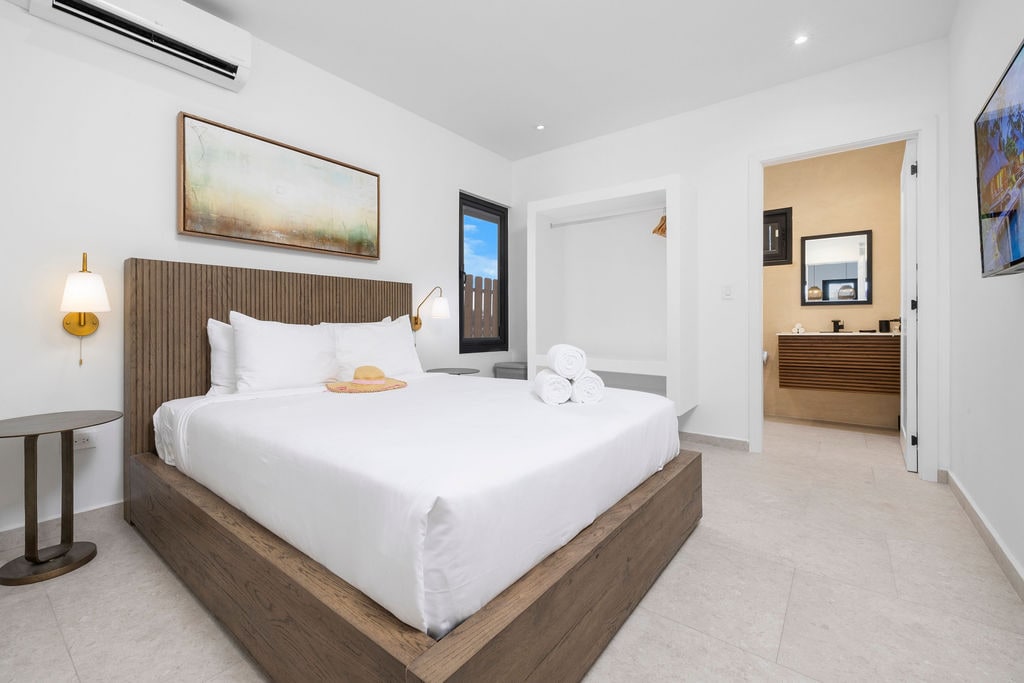 חדר שינה מואר עם מיזוג אוויר, טלוויזיה חכמה וגישה ישירה לחדר רחצה פרטי - נוח ונוח.