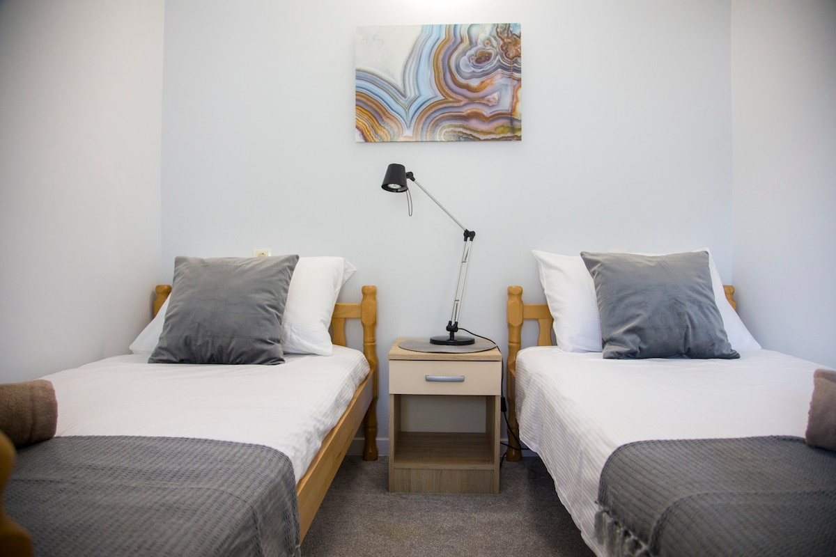 ห้องนอนที่สองมีเตียงสบาย 2 เตียง พรมที่มีสไตล์ และวิวสระว่ายน้ำ มีทางเข้าที่แยกจากโถงทางเดินเพื่อให้มีความเป็นส่วนตัวและความสงบ