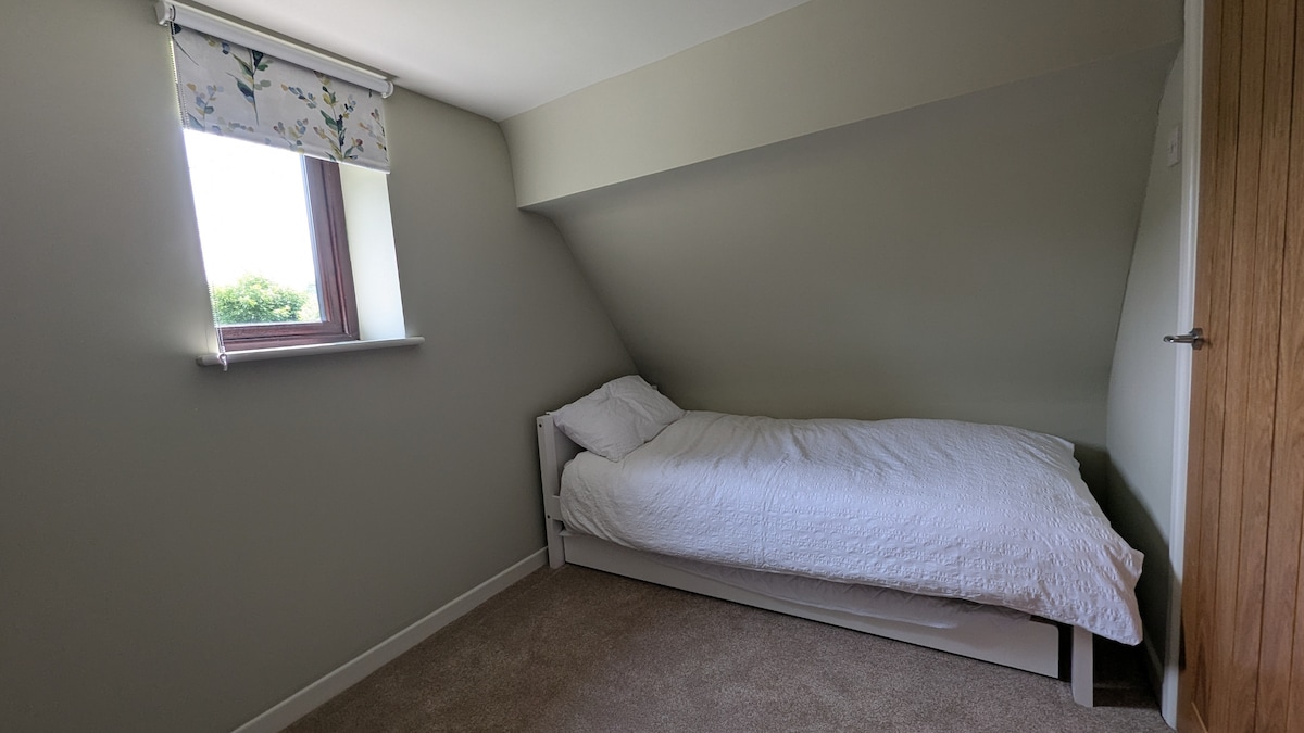 Un acogedor espacio de dormitorio fuera del dormitorio 2, ideal para niños, con una cama individual. Una cama plegable debajo proporciona espacio para otra (no se proporciona ropa de cama para la cama plegable).