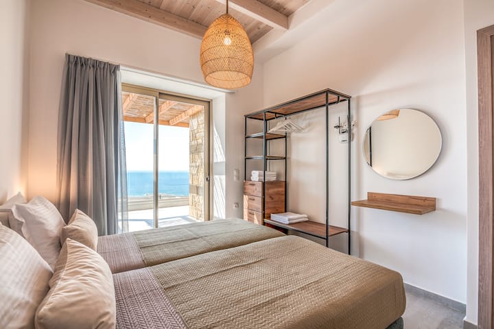Bedroom 1 with 2 single beds, ensuite bathroom and balcony with sea view